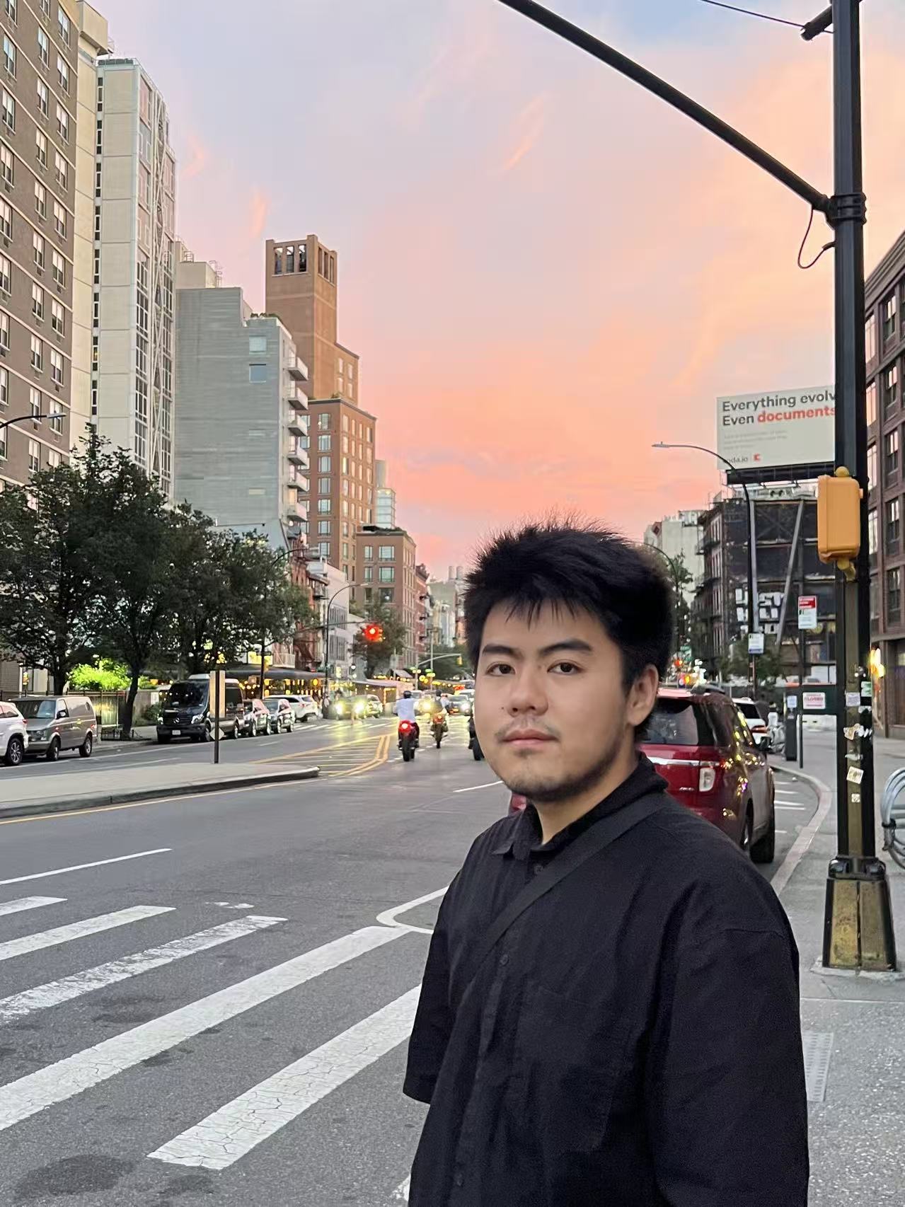 Yidong He on a city street at sunset